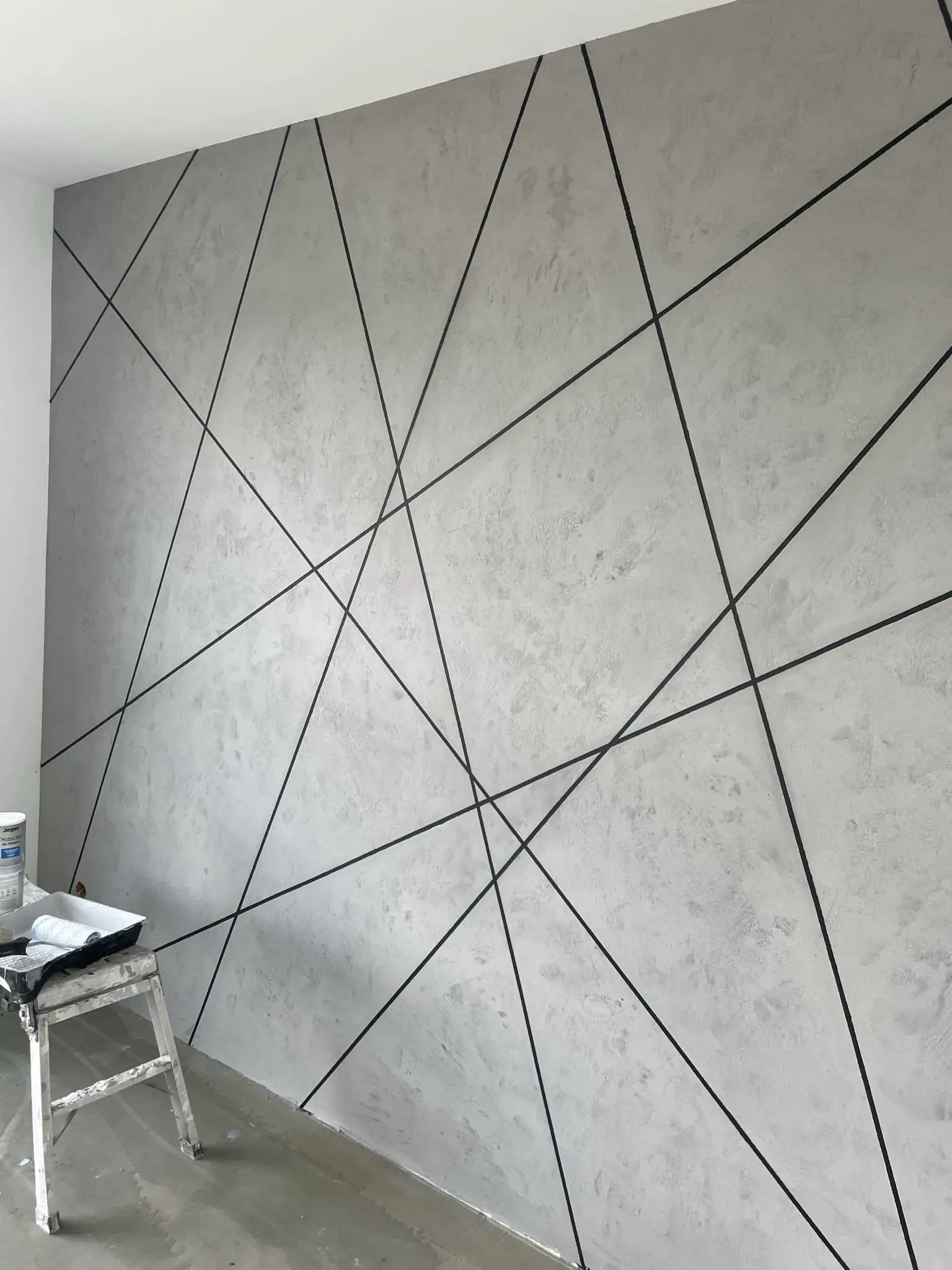 Dekoracyjna ściana z betonu architektonicznego z czarnymi liniami - usługi remontowe Trójmiasto